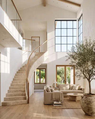 A bright white living room with a staircase